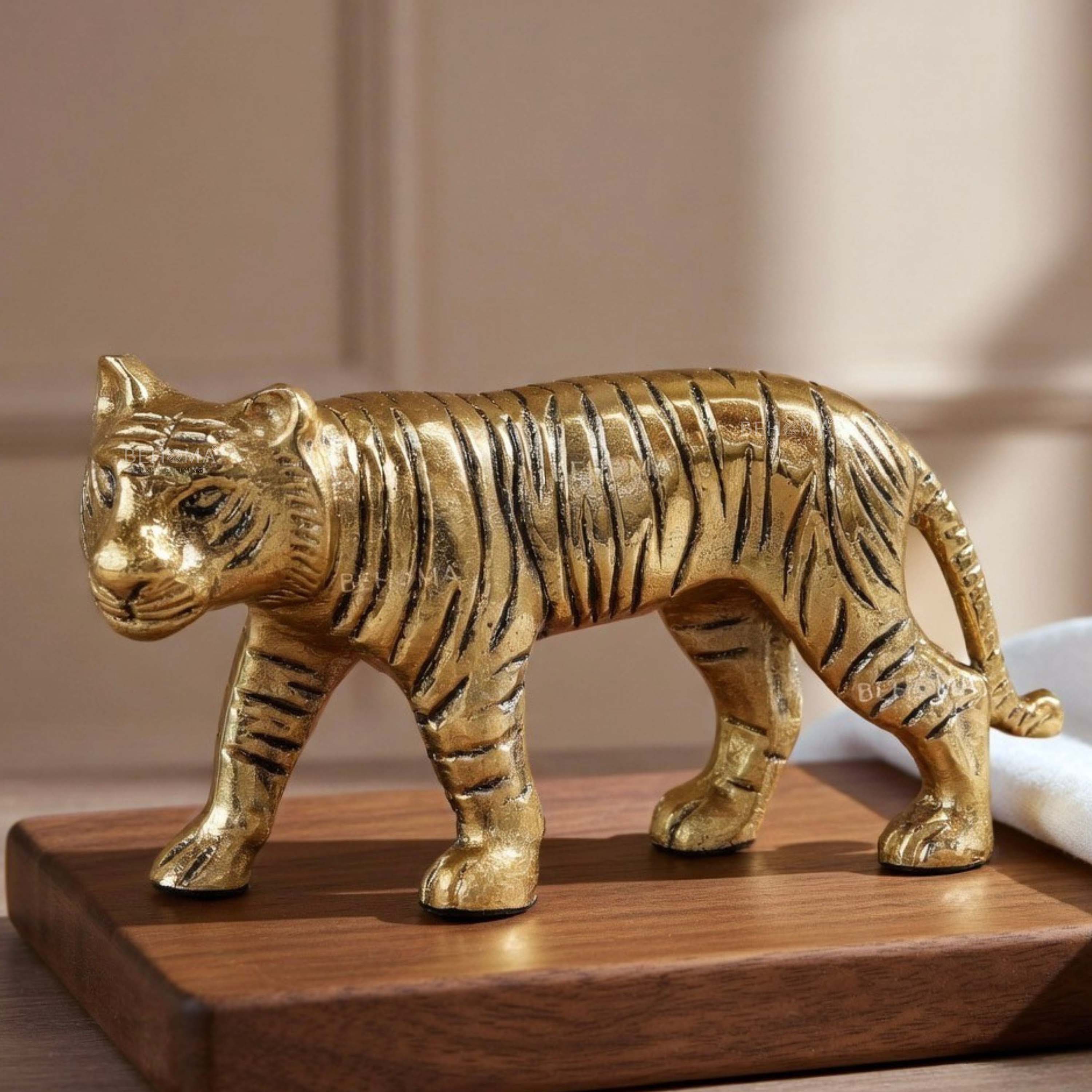 Gold tiger figurine on a wooden base with a neutral background, Tiger Figurine