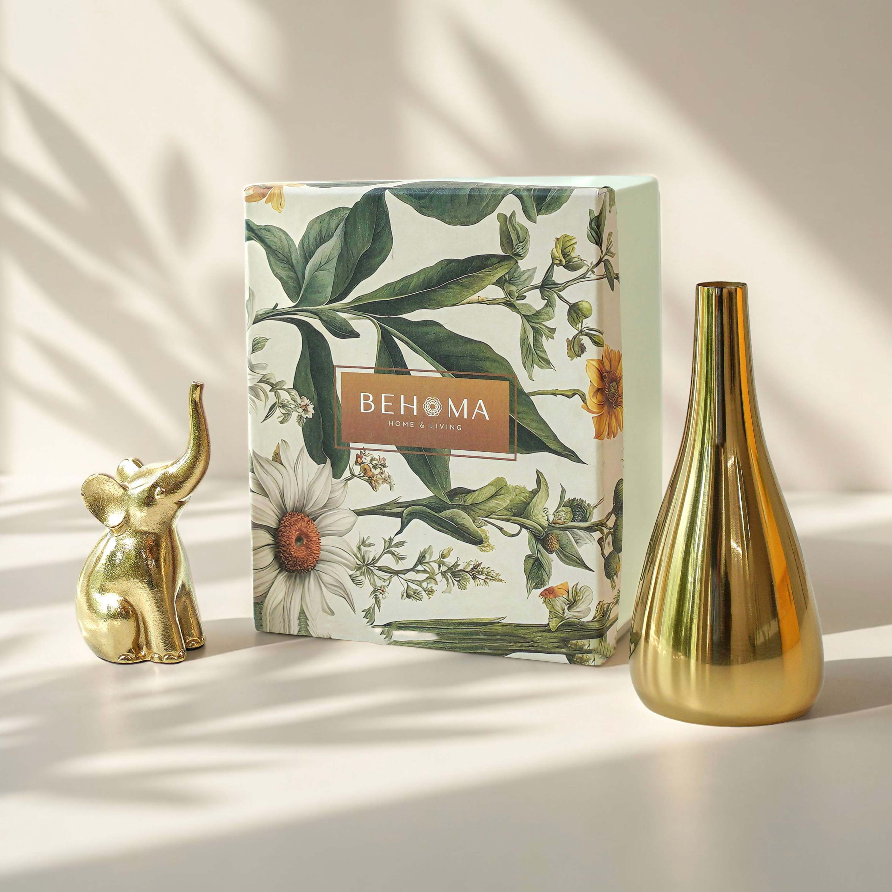 Decorative box with floral design and 'BEHOMA' branding, accompanied by a gold vase and elephant figurine on a light surface, Golden Trunk Gift Set