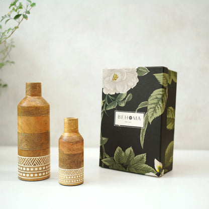 Two wooden vases with decorative patterns next to a black box with floral design and 'BEHOMA' branding.