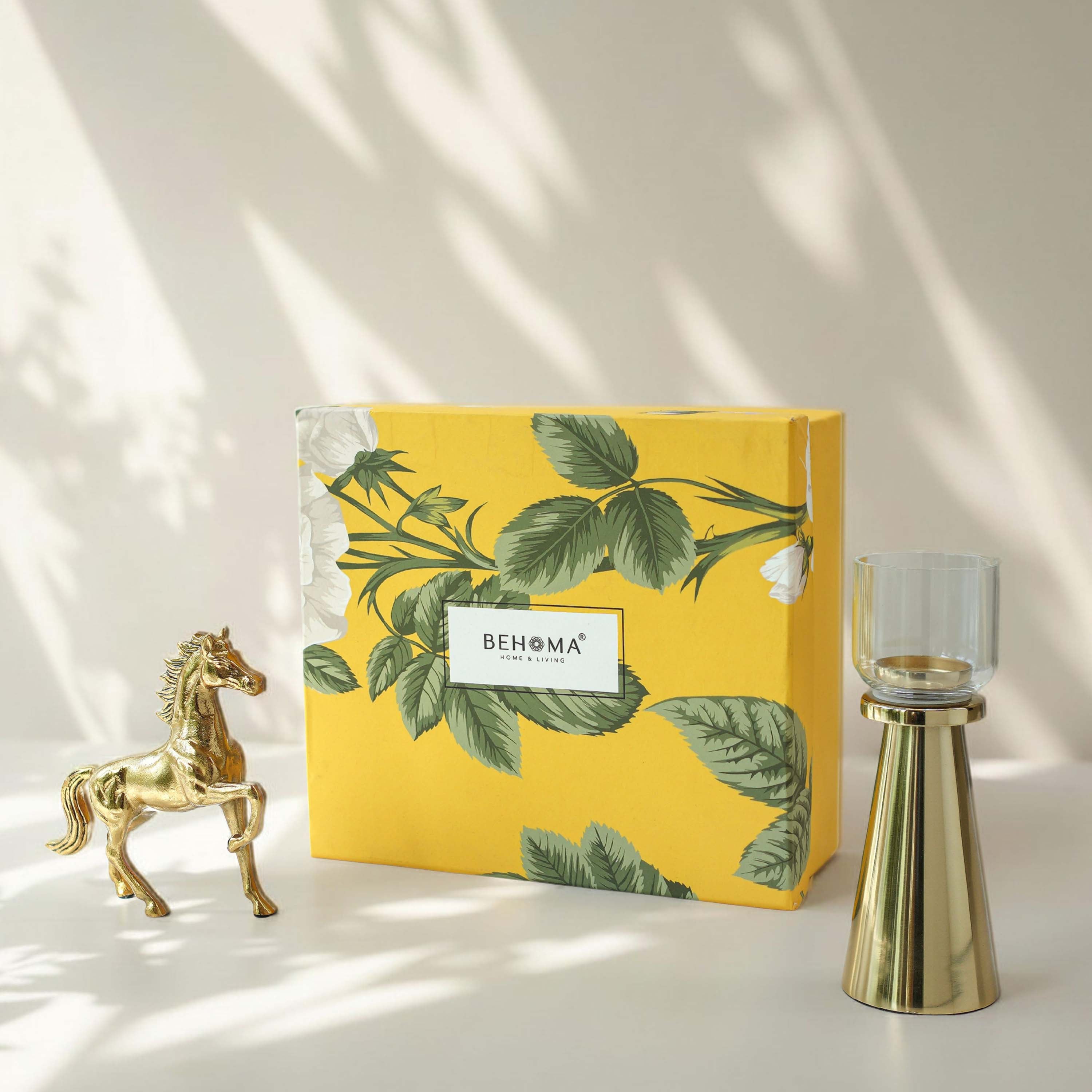 Yellow decorative box with green leaf pattern and 'BEHOMA' branding, accompanied by a gold horse figurine and candle holder on a light background, Royal Glow Gift Set